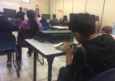 A student examines a motherboard in the back of class.