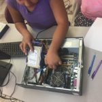 After a short lesson on hardware components and operating systems, students take turns disassembling and reassembling a desktop.