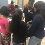 The AZStRUT volunteer gives three students some tips for handling hardware.